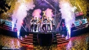 Team Secret stand on stage with confetti falling over them as Puppey holds up the DreamLeague trophy to the crowd