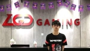 Ahjit stands in the offices of LGD Gaming wearing his new PSG.LGD jersey, there are streamers and festive decorations behind him.