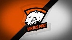 Логотип Virtus.pro на оскалившемся белом медведе появляется на оранжево-белом фоне, пересекаемом черной линией.