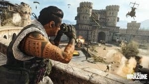 A screen from WarZone showing an operative peers down at a battlefield through binoculars as helicopters approach