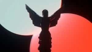 The winged trophy given out to winners at The Game Awards appears silhouetted against a bright orange sunset.