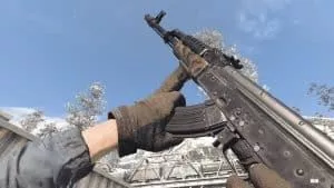 An in-game screen from Call of Duty, in first-person player point of view, showing the AK-47 raised and at the ready