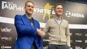 Danylo “Zeus” Teslenko shakes hands with fellow business partner in celebration of Fantastic Seven's signing