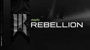 Слова «Shopify Rebellion» появляются на фоне черно-белого неба.  Стилизованная буква R появляется на развернутом флаге в левой части кадра.