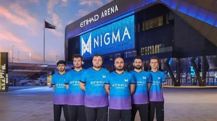 Члены команды Dota 2, Team Nigma, стоят перед заявлением Etihad с логотипом своей команды, отображаемым на ЖК-экране стадиона.