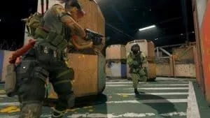 An operator takes cover behind large orange storage crates as an enemy charges toward them on the Call of Duty Gulag map