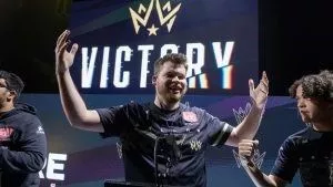 Call of Duty League player Ian “Crimsix” Porter holds his hands up in the air with a smile on his face after a match win.