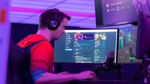 Стример видеоигр и создатель контента Бенджамин «DrLupo» Лупо играет в Fortnite на своем ПК в комнате с тусклым пурпурным освещением.