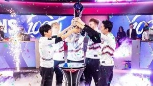 The 100 Thieves LCS team of Ssumday, Closer, Abbedagge, FBI and Huhi all hoist the LCS trophy while confetti reigns down on them.