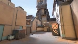 A screenshot from the new Valorant map Fracture, showing the desert biome half of the facility with tan buildings and crates pushed to the walls.