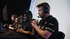 Ян «Crimsix» Портер сидит со своими товарищами по команде Call of Duty League на сцене перед матчем.