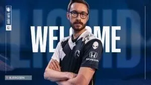 Pro LoL player Soren “Bjergsen” Bjerg stands with his arms crossed in a TL jersey with the words 