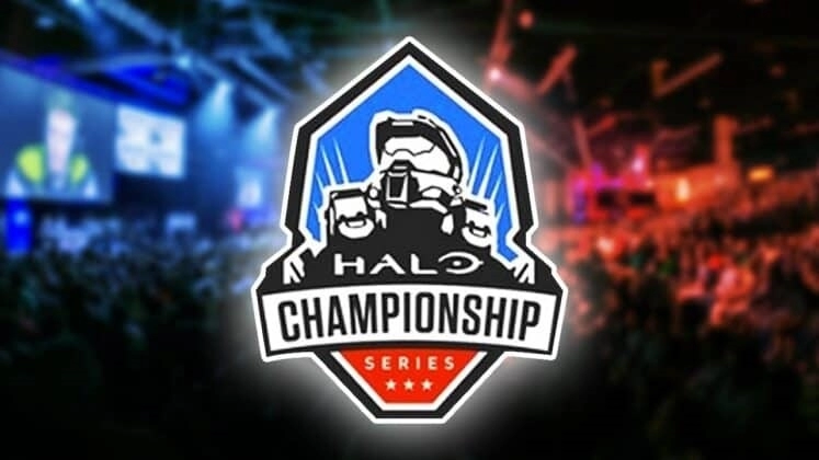 Логотип Halo Championship Series (HCS) со шлемом Мастера Чифа показан на фоне живой публики, наблюдающей за киберспортивными событиями под синим и красным светом.