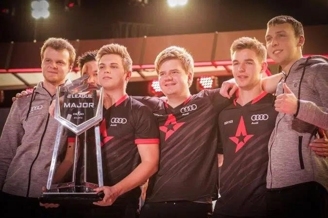 Устройство Astralis dupreeh xyp9x gla1ve на сцене 2017 eleague major с kjaerbye, держащим трофей на сцене